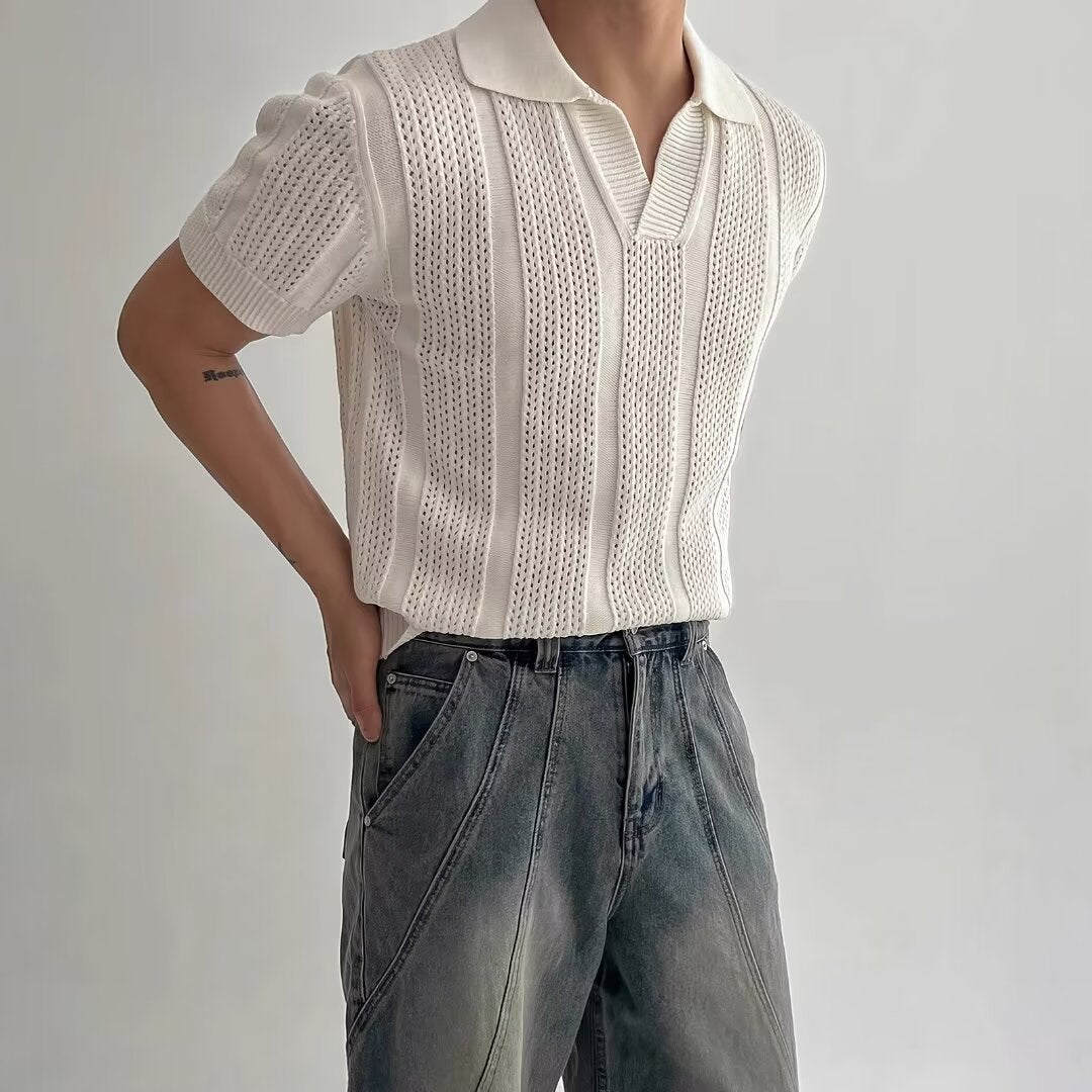 Maglietta bianca a maniche corte in maglia traforata, indossata con jeans casual. Stile estivo elegante, moda uomo contemporanea.