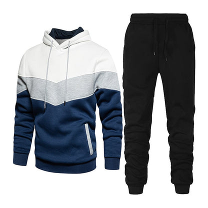 Tuta sportiva uomo, felpa con cappuccio tricolore blu, grigio e bianco, pantaloni neri. Abbigliamento casual, moda uomo, comfort quotidiano.