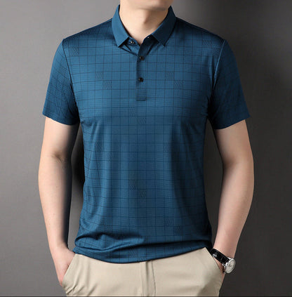Uomo con polo blu a quadri, maniche corte, abbinata a pantaloni beige. Moda casual maschile, abbigliamento estivo elegante.