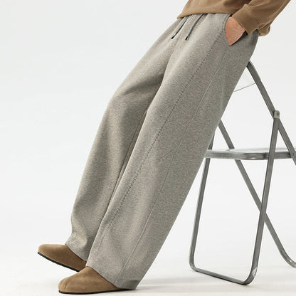 Herre-sweatpants med brede ben og løs pasform, elastik i taljen, snøre og sidelommer.