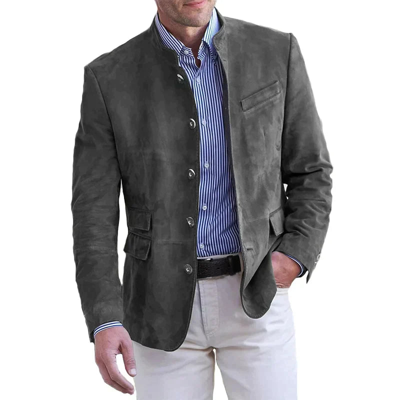Giacca uomo in pelle scamosciata grigia, stile casual elegante, abbinata a camicia a righe blu e pantaloni bianchi. Moda maschile autunnale.