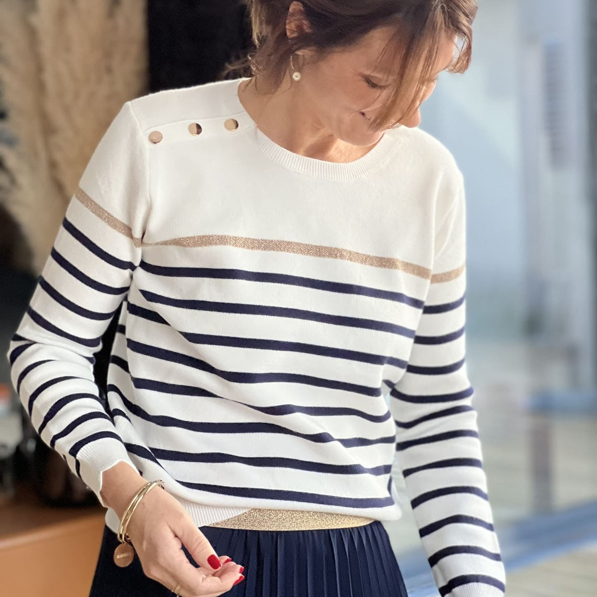 Women's striped knit sweater with a crew neck and shoulder buttons