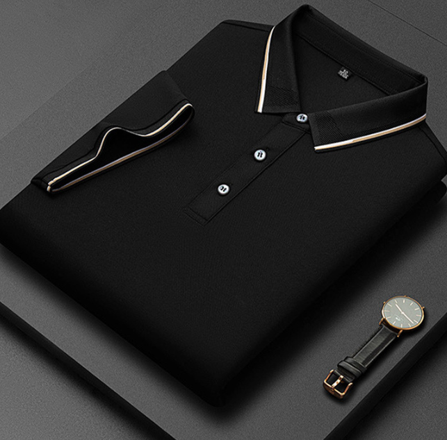 Camicia polo nera piegata con colletto a contrasto, bottoni bianchi, su sfondo grigio. Orologio elegante con cinturino in pelle accanto.