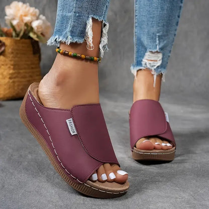 Sandali donna viola con zeppa, indossati con jeans strappati. Design moderno, comodi per l'estate. Accessorio alla caviglia con perline colorate.