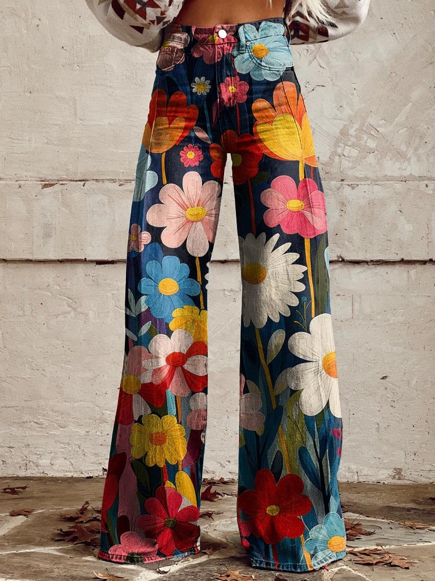 Jeans a zampa d'elefante con stampa floreale colorata su sfondo blu, indossati da una persona. Moda vintage, pantaloni floreali, stile anni '70.