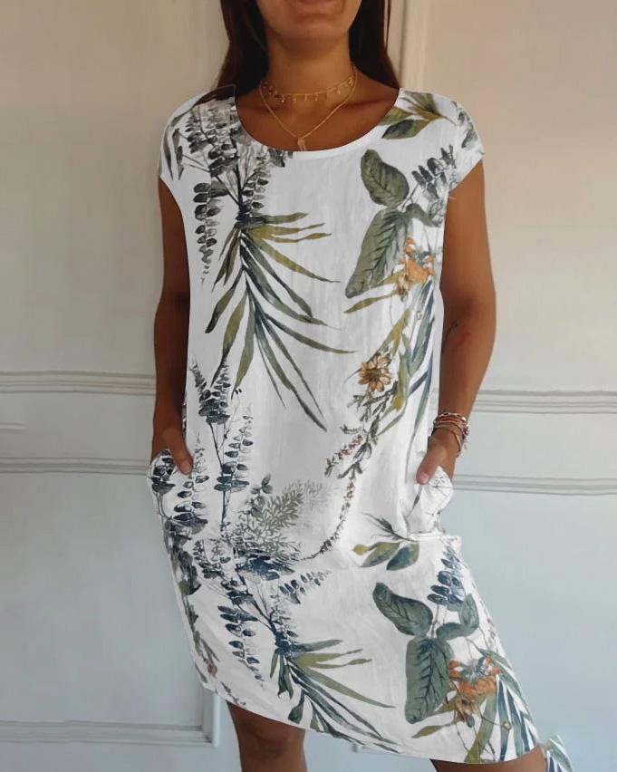 Abito estivo bianco con stampa floreale tropicale, maniche corte, tasche laterali. Perfetto per moda donna casual e look estivo elegante.