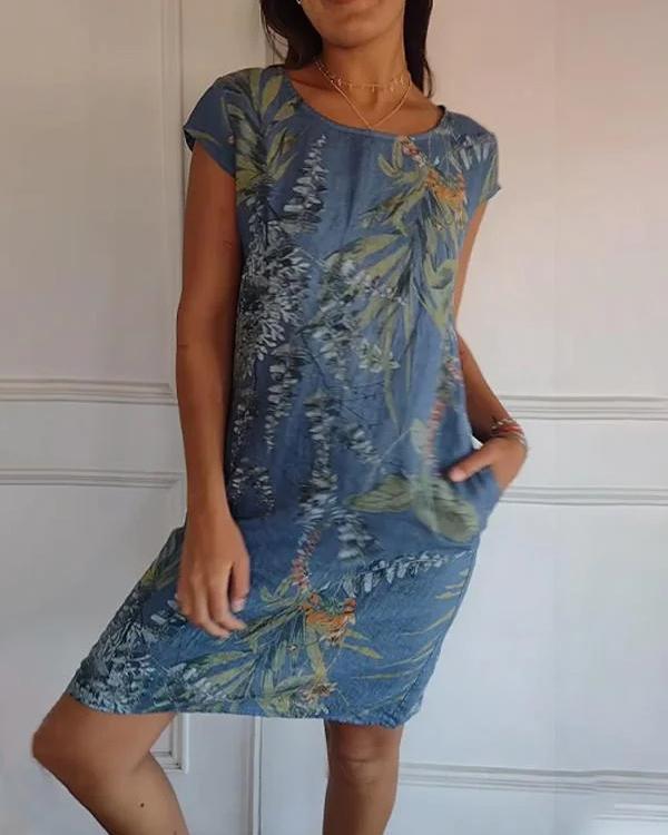 Abito estivo donna in denim con stampa floreale, maniche corte, tasche laterali. Moda casual, stile fresco e leggero per la stagione calda.