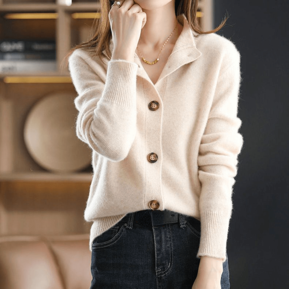 Maglione beige in cashmere con bottoni grandi, indossato da una donna. Moda autunnale elegante, abbinato a jeans scuri. Stile casual chic.