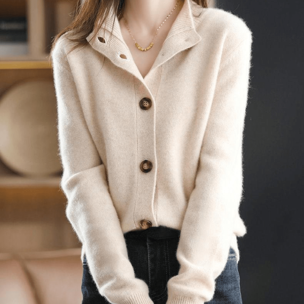 Maglione beige in cashmere con bottoni grandi, indossato da una donna. Moda autunnale elegante, abbinato a jeans scuri. Stile casual chic.