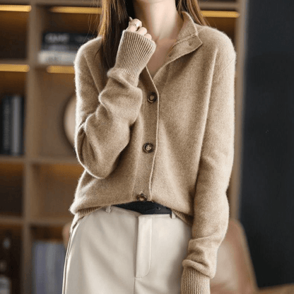 Donna con maglione beige in cashmere, maniche lunghe, abbinato a pantaloni chiari. Moda autunnale elegante, stile casual chic.