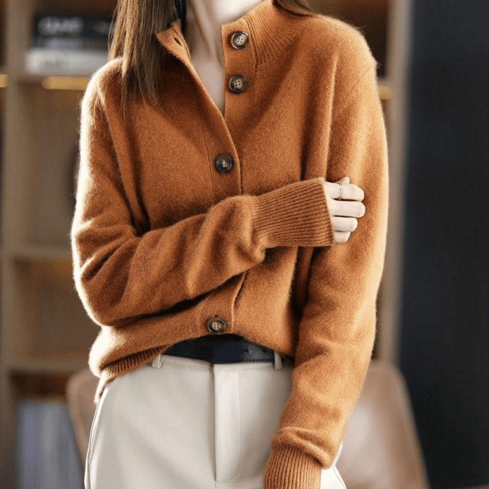 Maglione marrone in cashmere con bottoni, indossato da una donna in pantaloni chiari. Moda autunnale elegante e calda.