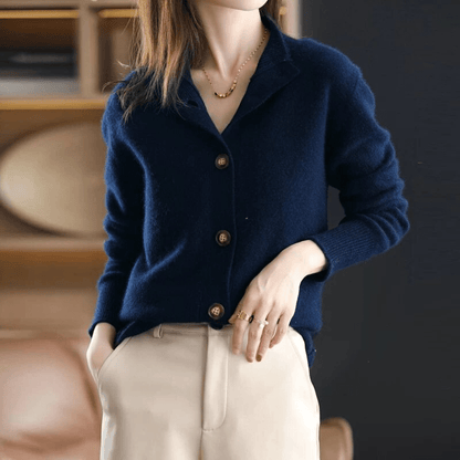 Donna con cardigan blu scuro in lana, bottoni in legno, pantaloni beige. Moda autunnale elegante, abbigliamento casual chic, stile minimalista.