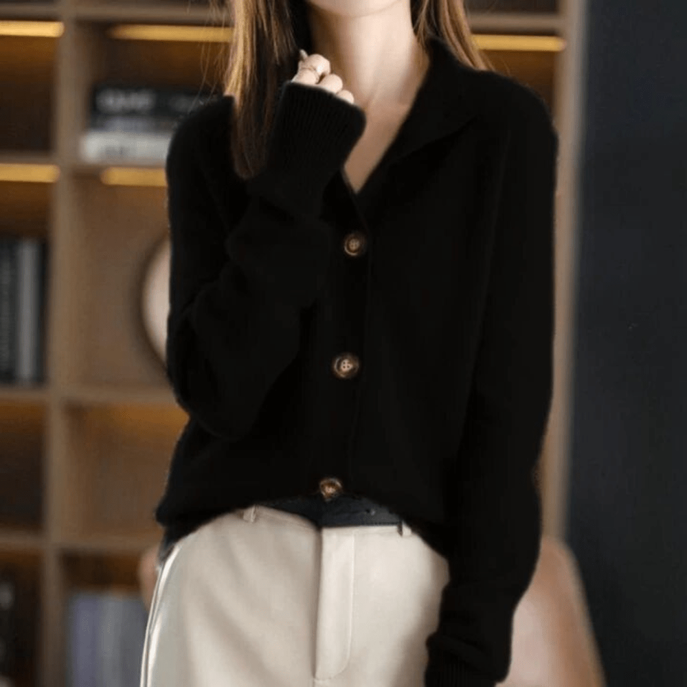 Donna con cardigan nero e pantaloni beige, sfondo libreria. Moda autunnale elegante, abbigliamento casual chic, tendenze moda 2023.