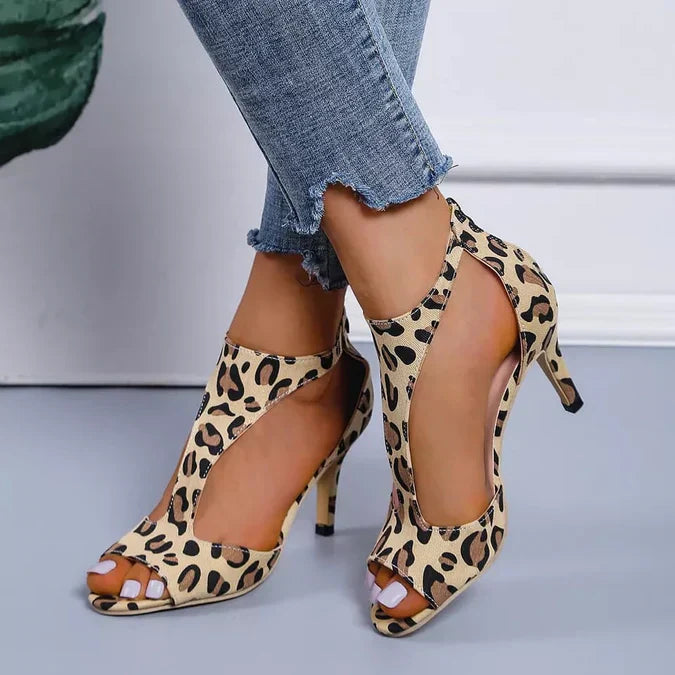 Sandali con tacco a spillo leopardati, indossati con jeans strappati. Scarpe eleganti da donna, moda estiva, stile animalier.