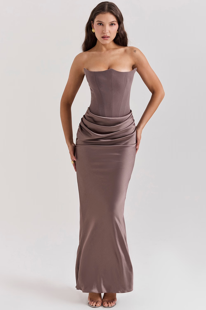 Donna in abito lungo elegante color taupe, senza spalline, con drappeggio in vita. Moda femminile, abbigliamento da sera, stile sofisticato.