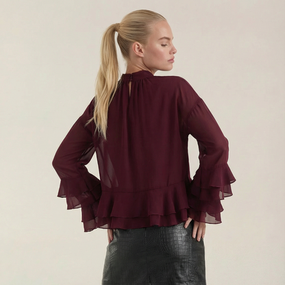 Blusa de mujer color burdeos de gasa transparente con mangas con volantes y cuello alto.