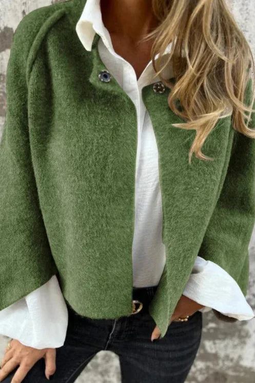 Donna con giacca verde elegante su camicia bianca, jeans neri. Moda autunnale, stile casual chic, abbigliamento femminile trendy.