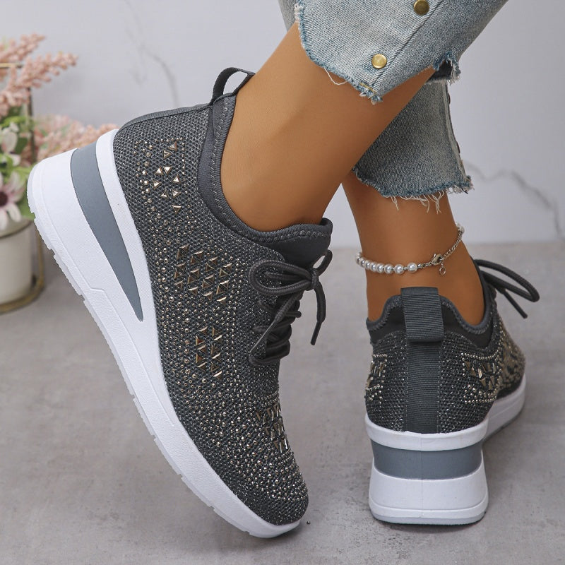 Scarpe da ginnastica nere con dettagli brillanti, suola bianca, indossate con jeans strappati. Moda casual, calzature eleganti, tendenze 2023.