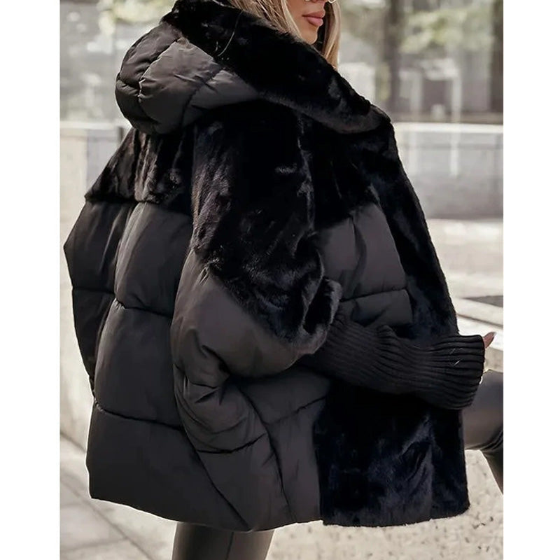 Donna con giacca invernale nera imbottita e cappuccio, dettagli in pelliccia sintetica, moda autunno inverno, stile urbano elegante.