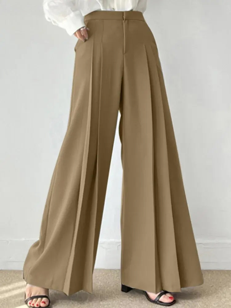 Pantaloni palazzo beige eleganti, vita alta, tessuto fluido, abbinati a camicia bianca. Moda donna, stile casual chic, tendenza abbigliamento 2023.