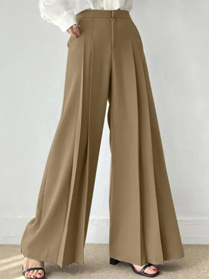 Pantaloni palazzo beige eleganti, vita alta, tessuto fluido, abbinati a camicia bianca. Moda donna, stile casual chic, tendenza abbigliamento 2023.