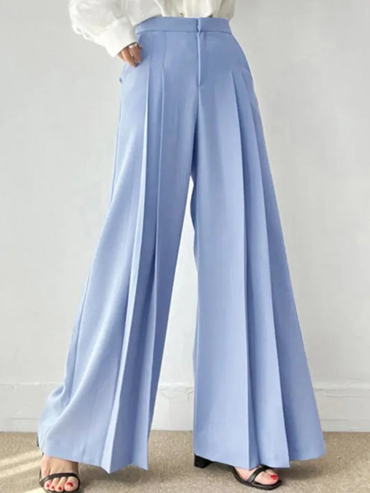 Pantaloni palazzo azzurri eleganti, a vita alta, con pieghe, indossati con camicia bianca. Stile moda donna, abbigliamento casual chic.