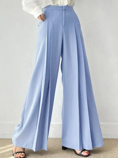 Pantaloni palazzo azzurri eleganti, a vita alta, con pieghe, indossati con camicia bianca. Stile moda donna, abbigliamento casual chic.