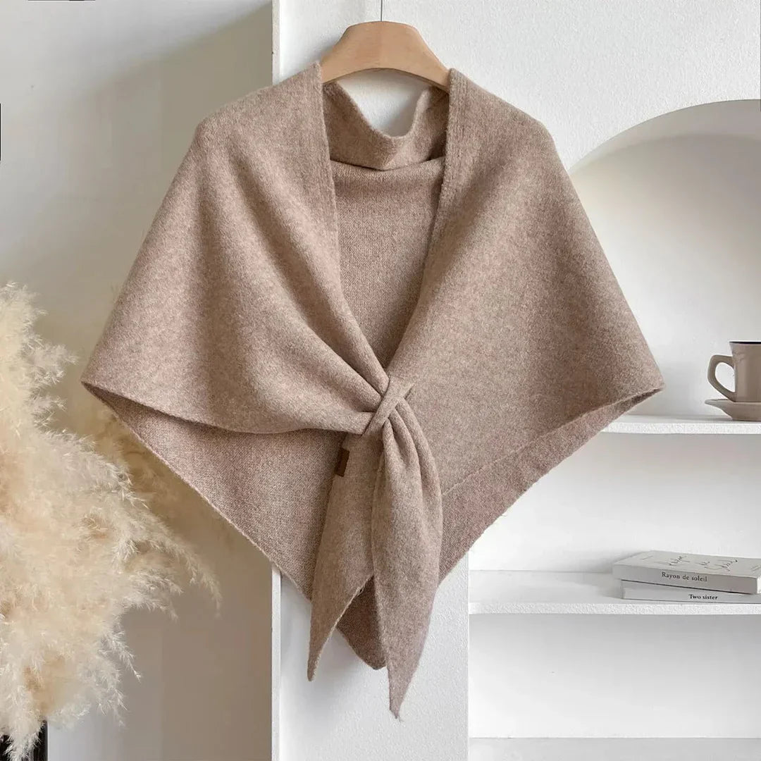 Scialle in cashmere beige su appendiabiti, design elegante e morbido, perfetto per moda autunno inverno. Sfondo minimalista con tazza e decorazioni.