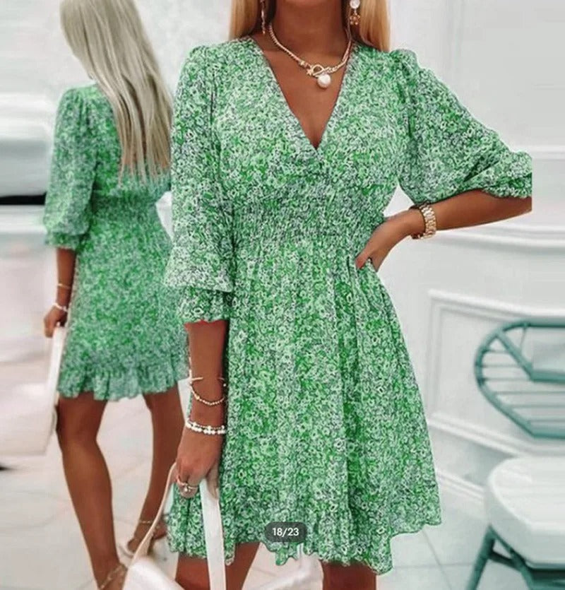 Abito estivo verde a fiori con maniche a tre quarti, scollo a V e vita arricciata. Moda donna elegante, perfetto per look casual e chic.