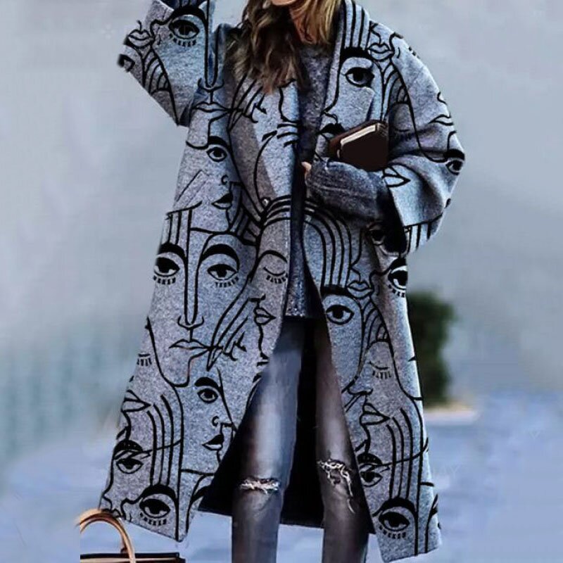 Cappotto grigio con stampa artistica di volti astratti, indossato da una donna con jeans strappati. Moda invernale, stile moderno, abbigliamento casual.