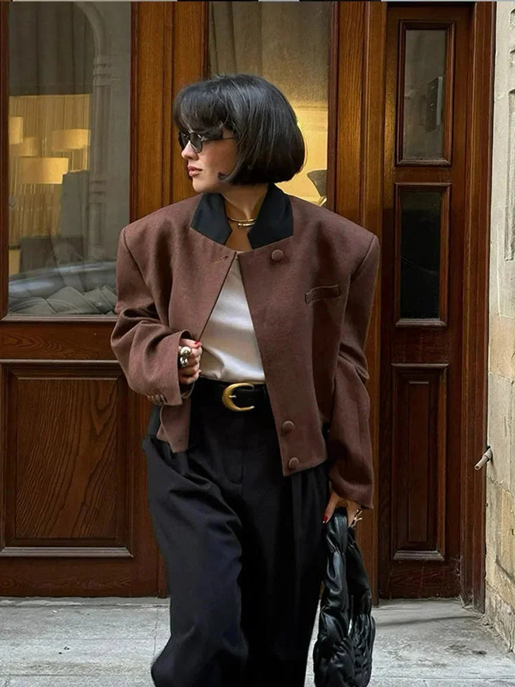 Women's cropped blazer for autumn with a notched collar, pockets, and padded shoulders.