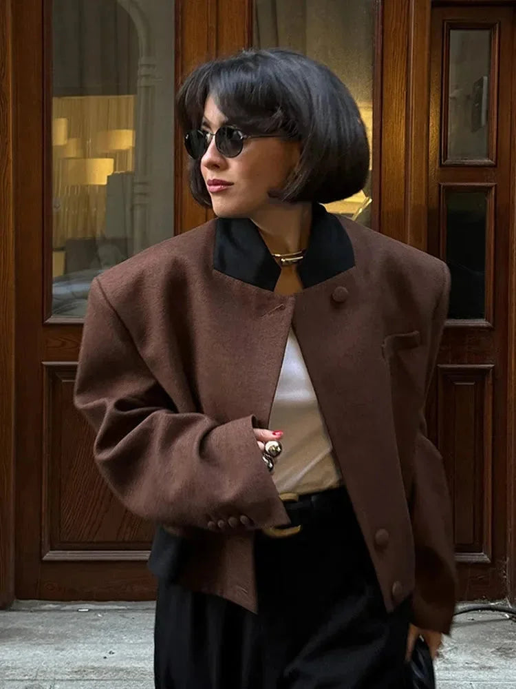 Women's cropped blazer for autumn with a notched collar, pockets, and padded shoulders.