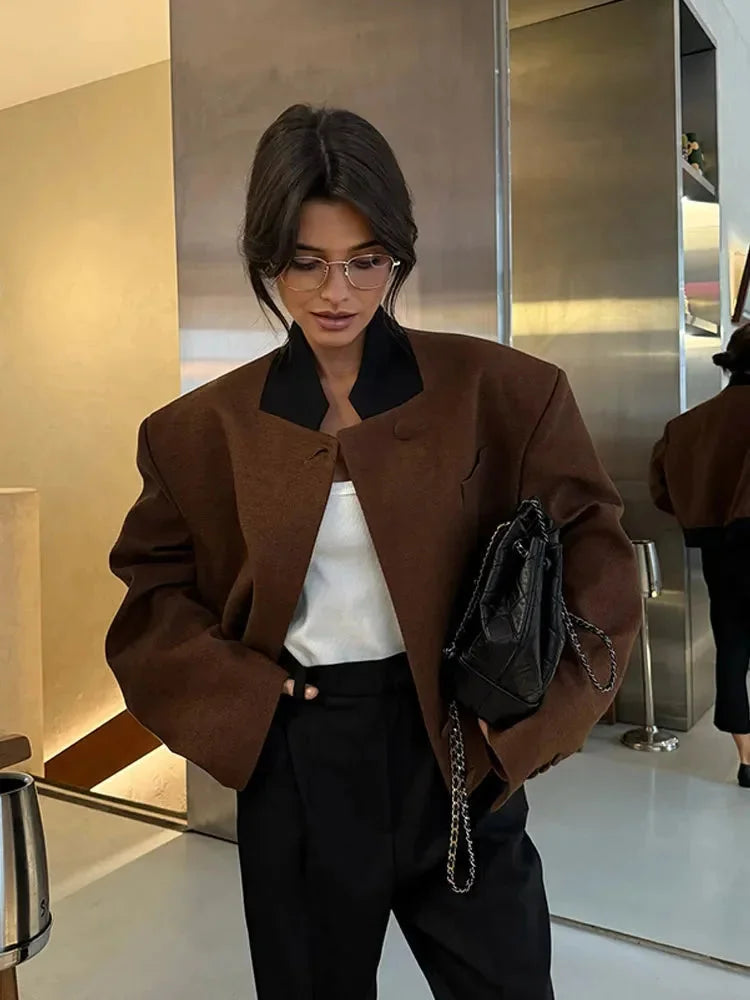Women's cropped blazer for autumn with a notched collar, pockets, and padded shoulders.