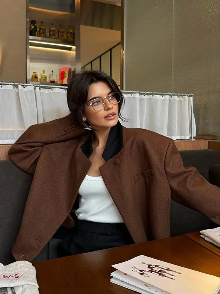 Women's cropped blazer for autumn with a notched collar, pockets, and padded shoulders.