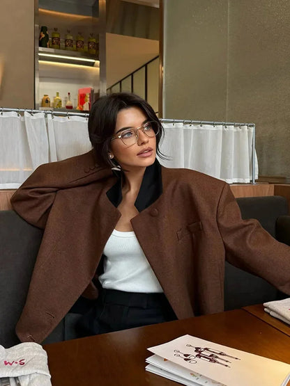 Women's cropped blazer for autumn with a notched collar, pockets, and padded shoulders.