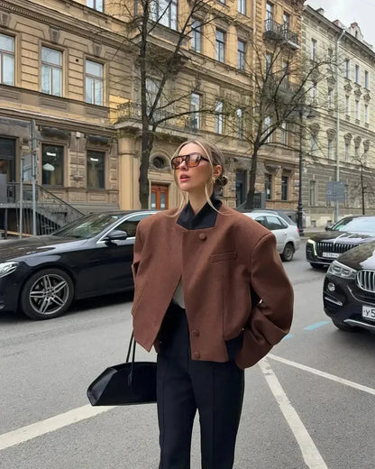 Women's cropped blazer for autumn with a notched collar, pockets, and padded shoulders.