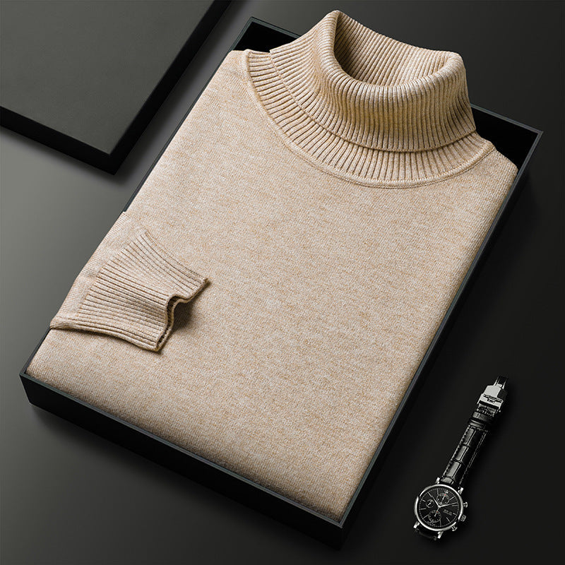 Maglione dolcevita beige piegato in scatola nera su sfondo scuro, accanto a orologio da polso elegante. Moda uomo, abbigliamento invernale di lusso.