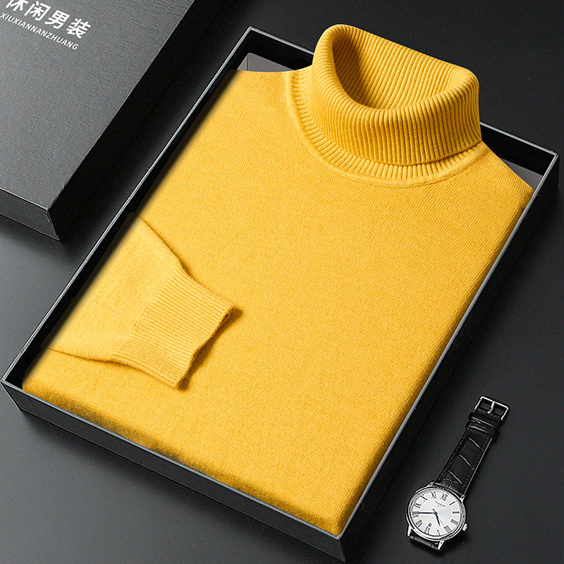 Maglione giallo a collo alto in scatola regalo nera, orologio da polso elegante accanto. Maglione invernale uomo, moda casual, abbigliamento caldo.