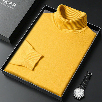 Maglione dolcevita giallo in lana, confezionato in elegante scatola nera, accanto a orologio da polso. Moda uomo, abbigliamento invernale.